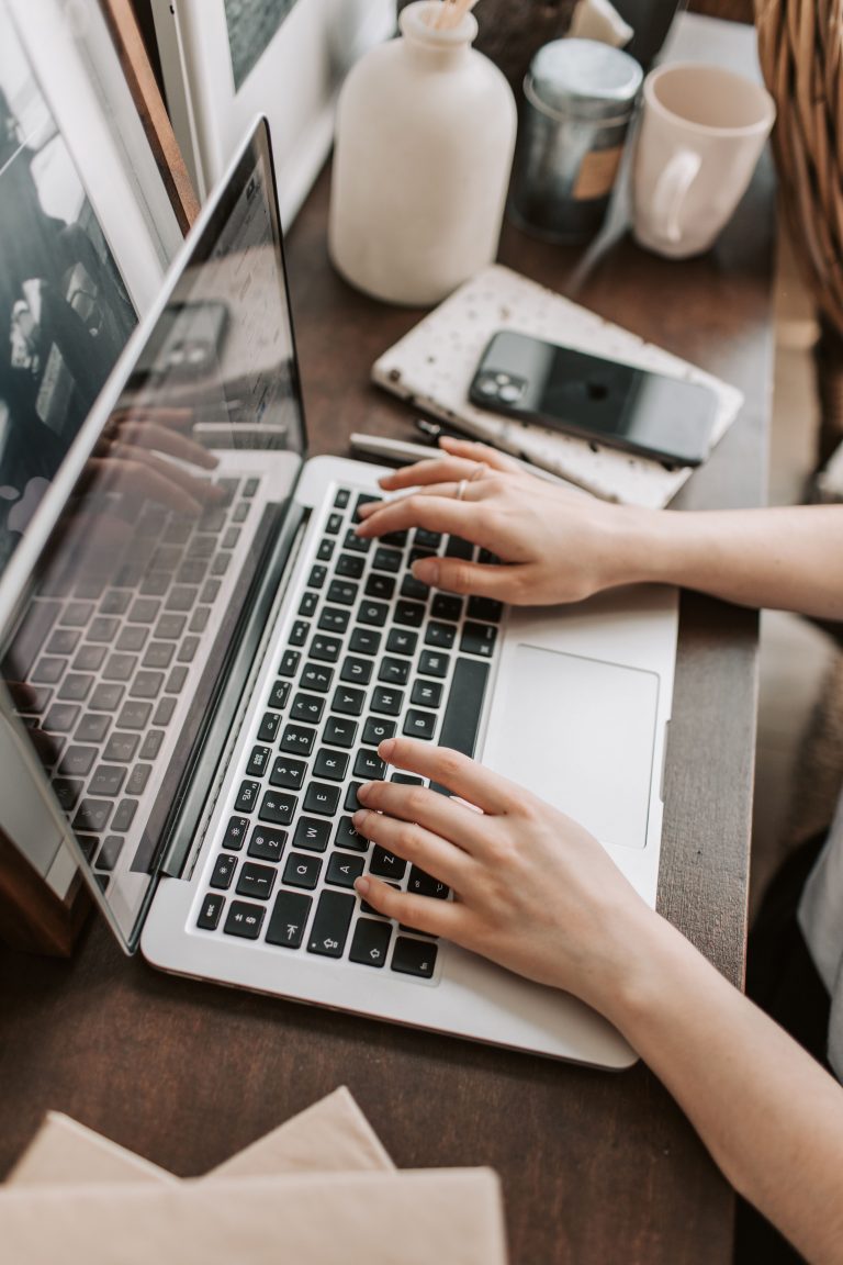 Femme freelance tapant sur son ordinateur portable à son bureau, vue de dessus, revenu complémentaire